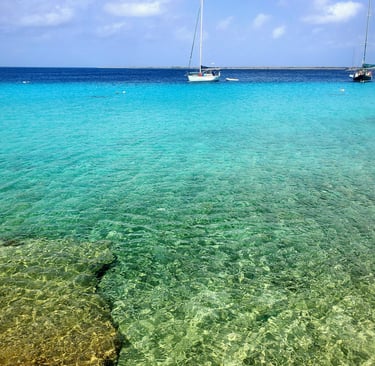 Bonaire waters with small sailboat. Crystal clear waters were scuba and snorkeling are world renown