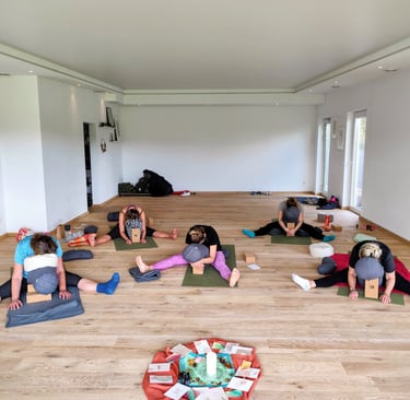 Yin-Yogastunde; Teilnehmende in Libellen-Pose