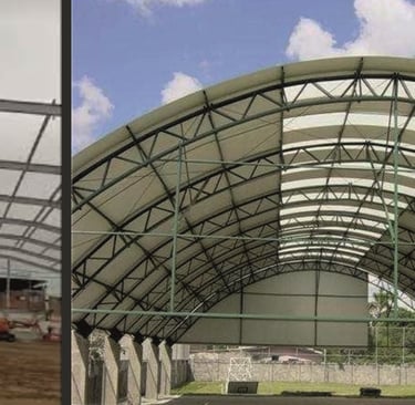 Steel frame construction and a finished arched metal roof structure for a sports court pavilion.