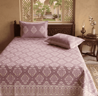 Mauve and white floral booti pattern Jaipuri bedsheet on a carved wooden bed