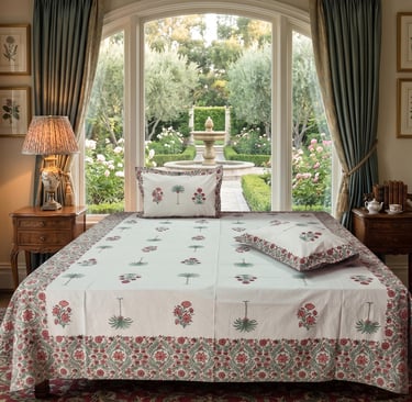 Luxury block print bedding on a bed facing a scenic garden window with a fountain view.