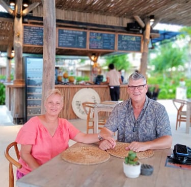 Couple enjoying a relaxed, tropical dinner in a resort restaurant. Ideal for Bali Retirement Visa clients.
