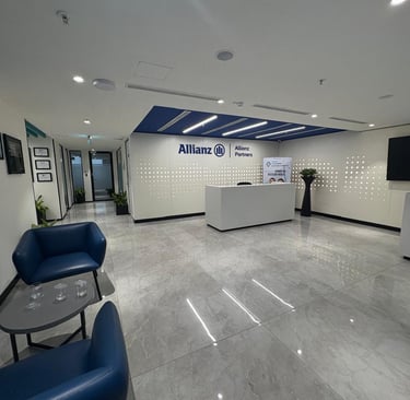 Modern Allianz Partners corporate office reception area with blue armchairs and marble floors.
