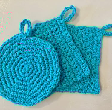 3 aqua colored crocheted face scrubbies stacked together