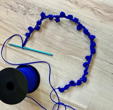 Royal blue cord crocheted into rosebuds with crochet hook