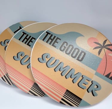 Set of retro round drink coasters with a palm tree beach sunset design and The Good Summer text.