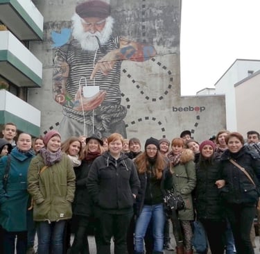 Group on street art tour in Hamburg in front of mural, Gruppe bei Street Art Tour vor Wandbild in Hamburg