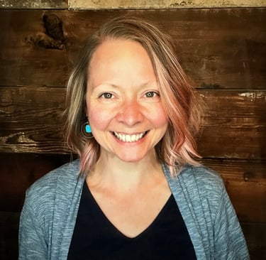 Image of Dr. Erika smiling against brown wood background