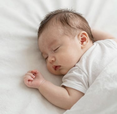 a baby sleeping with a stuffed animal