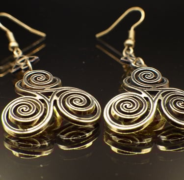 a pair of brass triskelion earrings with triquetra accents, custom cut out of 1.64mm brass