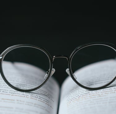 Um óculos preto sobre um livro aberto