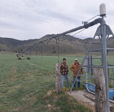 Men standing by pivot irrigation