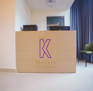 Modern hotel reception desk with K Hotels branding and elegant minimalist interior design.