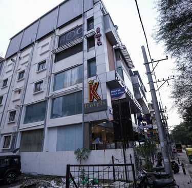 Exterior view of the K Hotels building with signage and street view in an urban city setting.