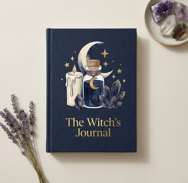 The Witch's Journal with moon and crystal illustrations next to dried lavender and healing stones.
