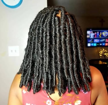 a woman with a large black butterfly locs