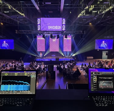 Professional live event production featuring laptops with audio monitoring software at a gala award show.