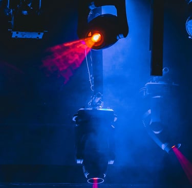 Professional stage lighting equipment projecting vibrant red laser beams through blue concert fog.