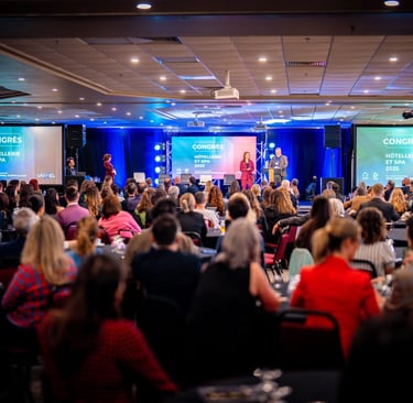 A speaker addresses a large audience at the 2025 Congress for Hospitality and Spa industries.