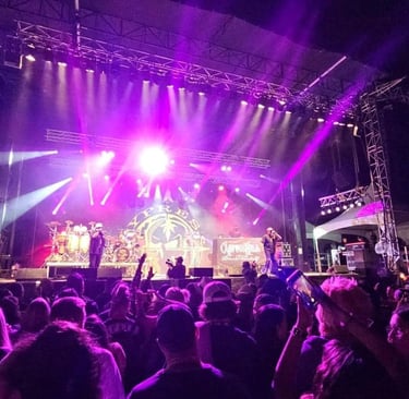 Cypress Hill performing live on a concert stage with purple lights and a large crowd.