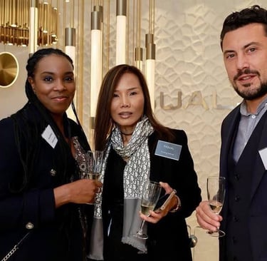 three people standing next to each other holding wine glasses