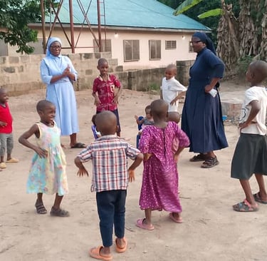 Catholic nuns play outdoor games with children at a community center in Africa.