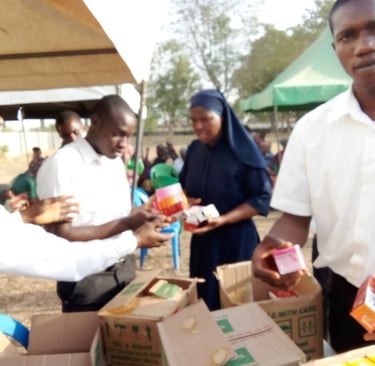 Health workers and a nun distributing essential medicine and supplies at an outdoor community outreach event.