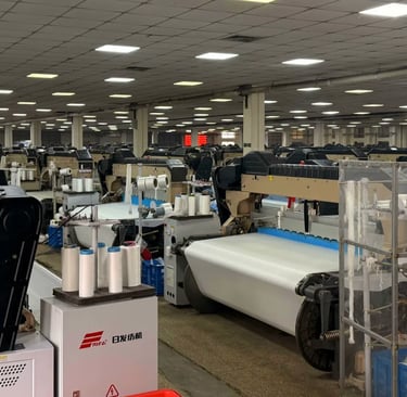 textile factory producing woven fabrics with industrial weaving equipment