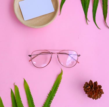 lentes transparentes sobre UN Fondo Rosa y al LADO UN como de pino con un cuenco y dentro un papel