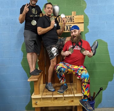 three men showing off their medals standing on a throne