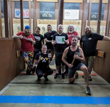 happy but tired group in an axe throwing arena