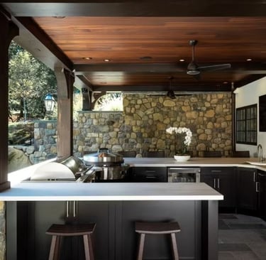 a kitchen with a stone wall and a bar stool