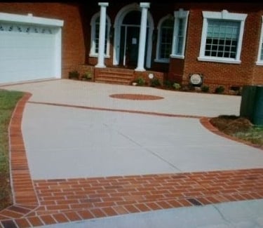 a brick house with a driveway with a driveway with brickwork