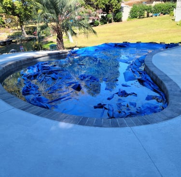 a pool with a blue tarp and a blue tarp