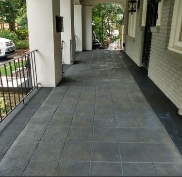 a long narrow walkway with a car parked on the side of the road