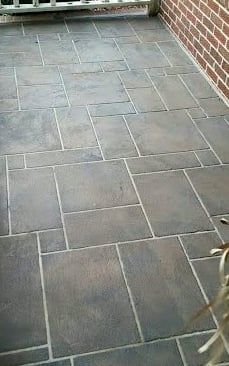 a patio with a brick wall and a planter