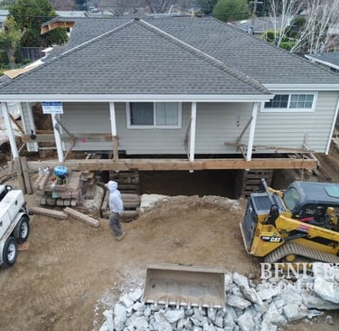Crew raising house and pouring new basement foundation