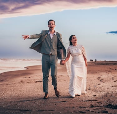 Pareja feliz corriendo en la playa después de boda, fotografía natural y espontánea en Pinamar