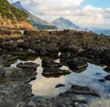 Suggestiva costa rocciosa e pozze di marea con vista sulle montagne di Maratea