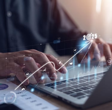 Business professional using a laptop with 2025 growth strategy icons and financial data charts.