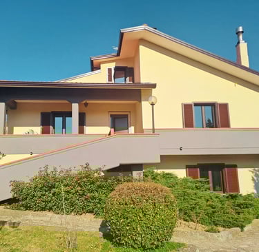 a house with a staircase leading up to a large balcony