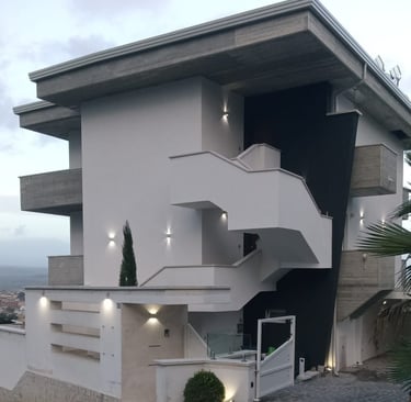 a white house with a spiral staircase leading to a balcony