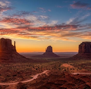 The sun rises behind West Mitten, East Mitten and Merrick Butte along the 17-mile loop in Monument Valley during a full moon