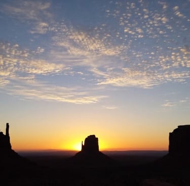 Monument Valley sunrise silhouettes West Mitten Butte, East Mitten Butte, and Merrick Butte