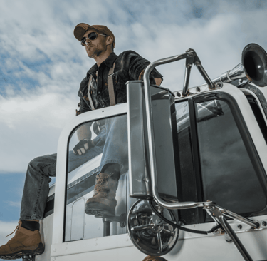 Happy Australian truck driver on cab using Safee NHVR-approved Electronic Work Diary EWD for fatigue compliance.