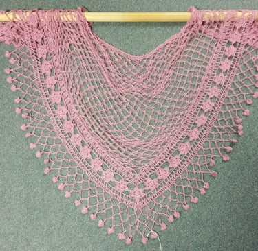 A pink hand-made lace shawl.