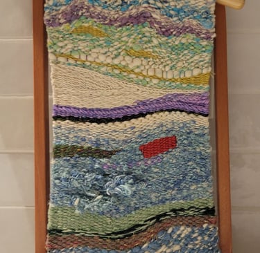 Hand-woven abstract tapestry on a frame.