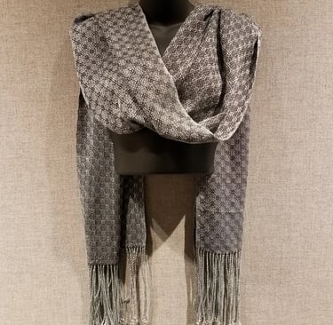 A grey colored hand-woven shawl on display at the Harm Museum of Art.