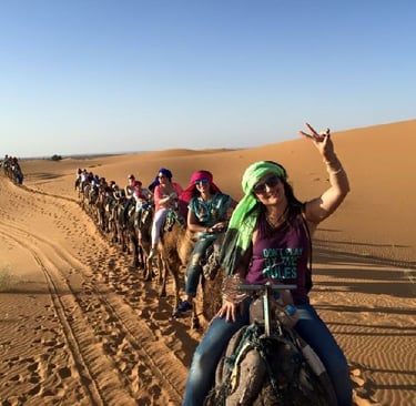 Dunas do Deserto do Saara ao pôr do sol, passeio de camelo em Marrocos, turismo de luxo.