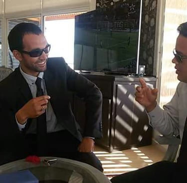 Casal gay brasileiro no Deserto do Saara, pôr do sol com camelos, viagem romântica Marrocos.